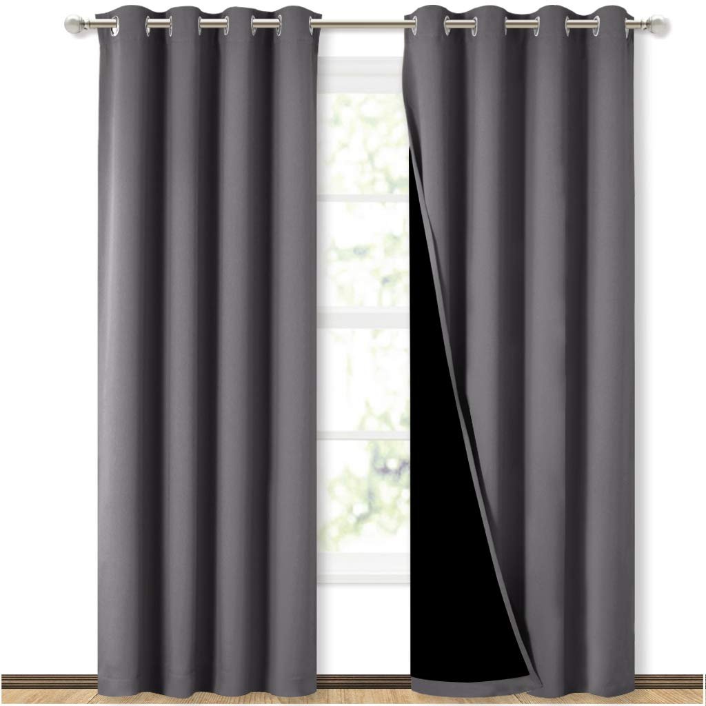 Gray curtains partially open, revealing a window and black lining