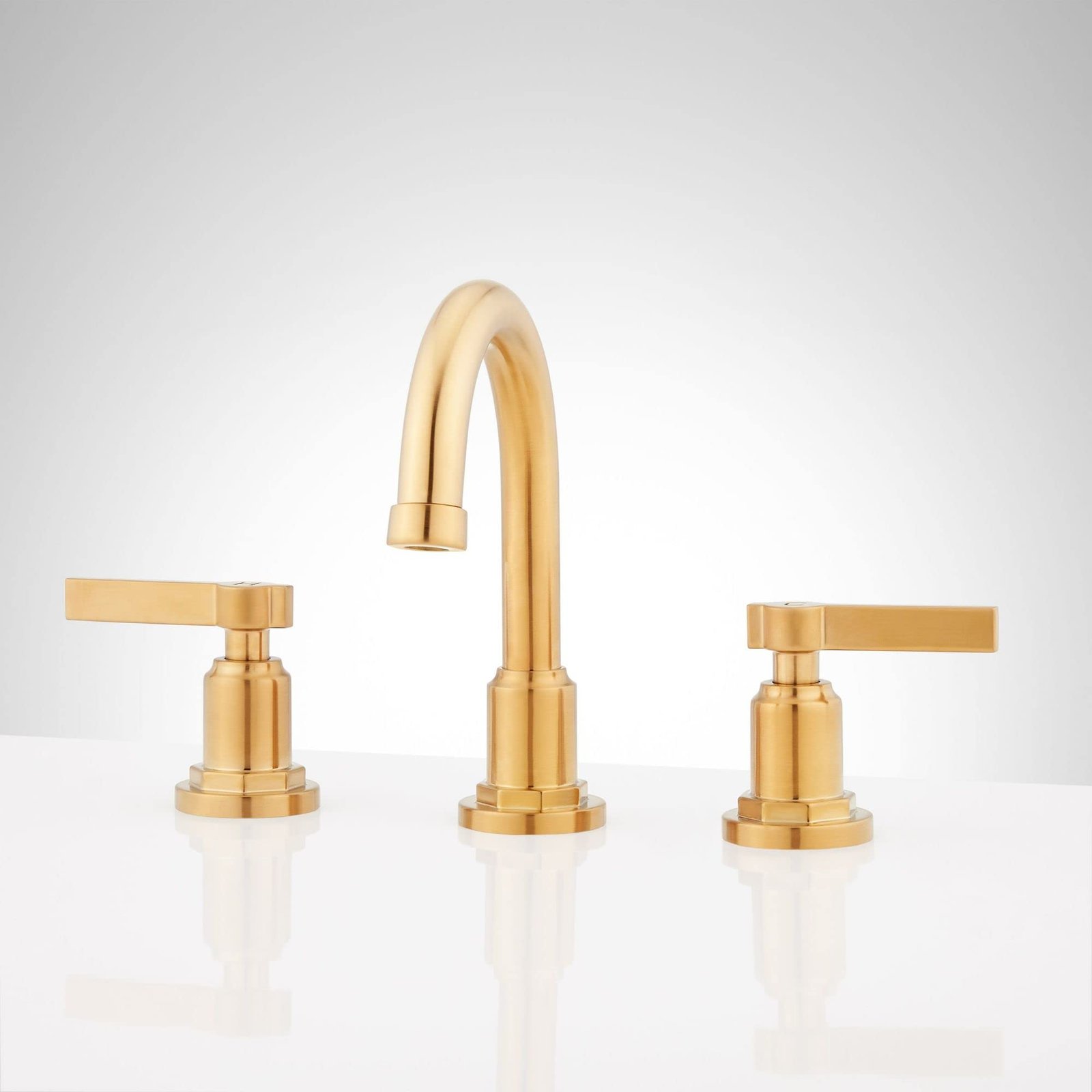 Gold-colored bathroom faucet with two handles and a curved spout