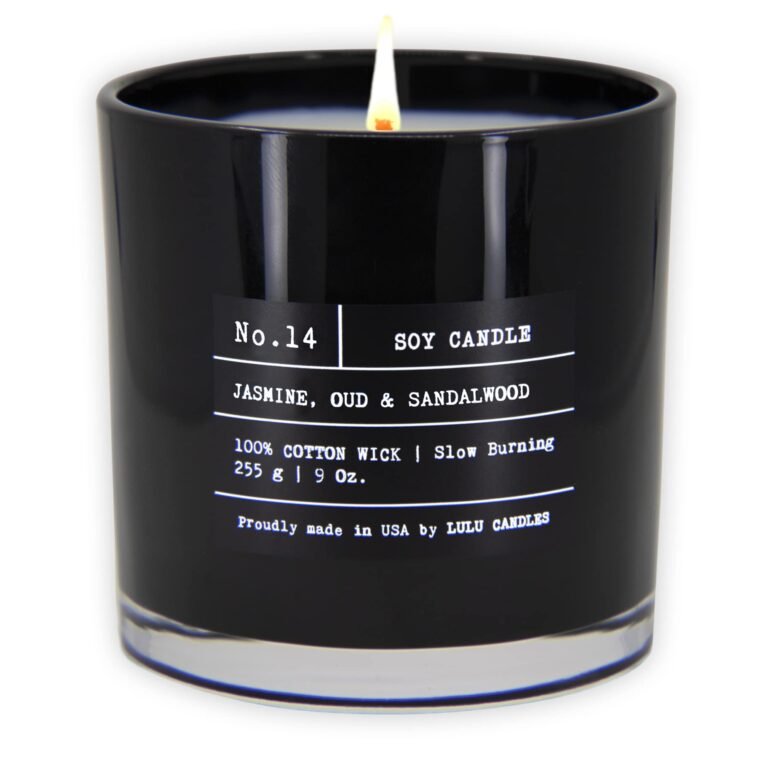 Lit black soy candle with label reading "Jasmine, Oud & Sandalwood"