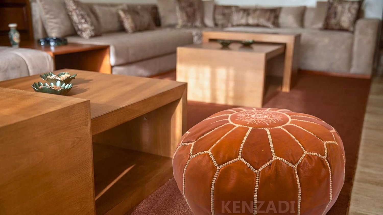 Brown leather ottoman in a living room with a sectional sofa