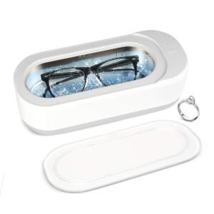 Eyeglasses in a white ultrasonic cleaner with a ring nearby