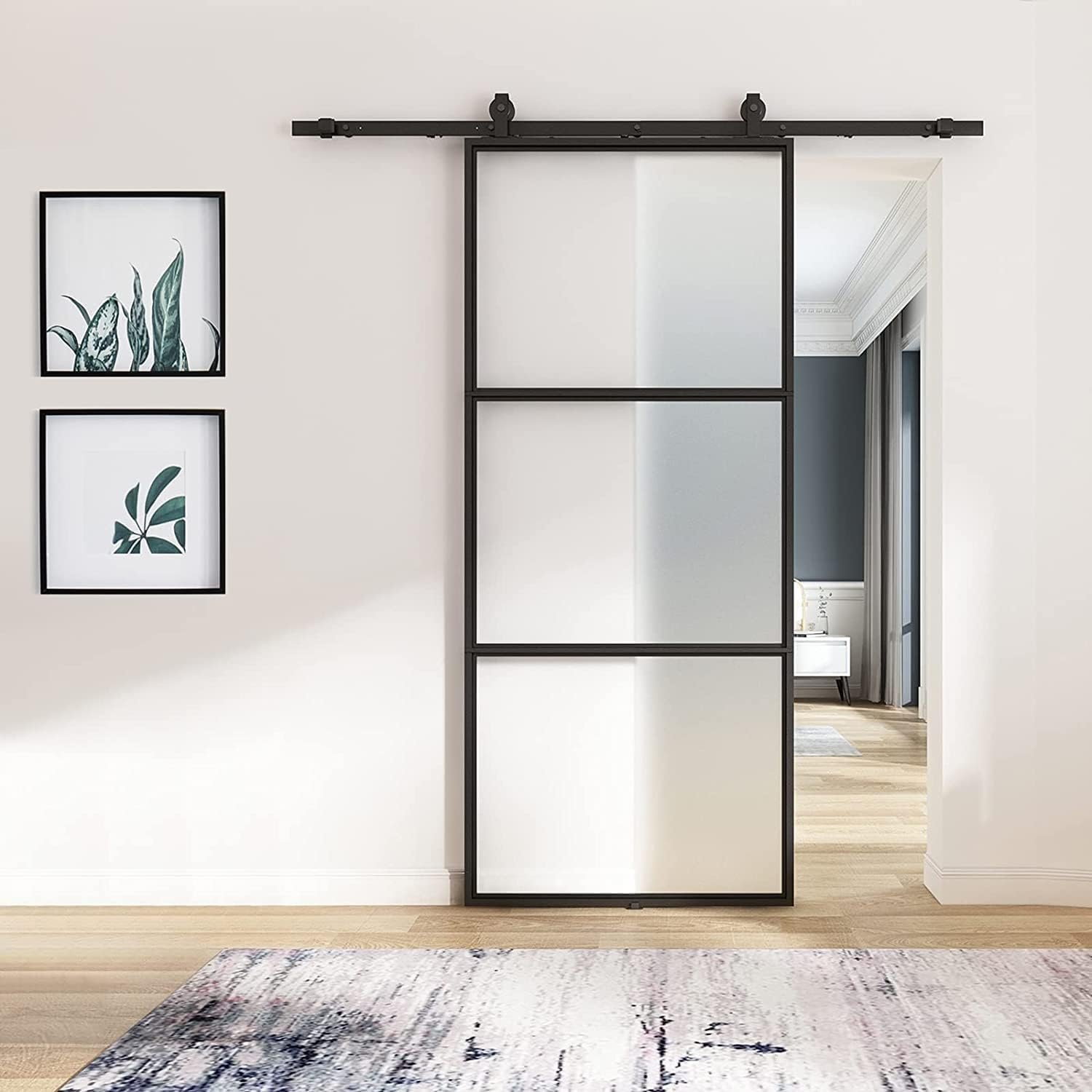 Modern sliding glass door with black frame, artwork, and rug