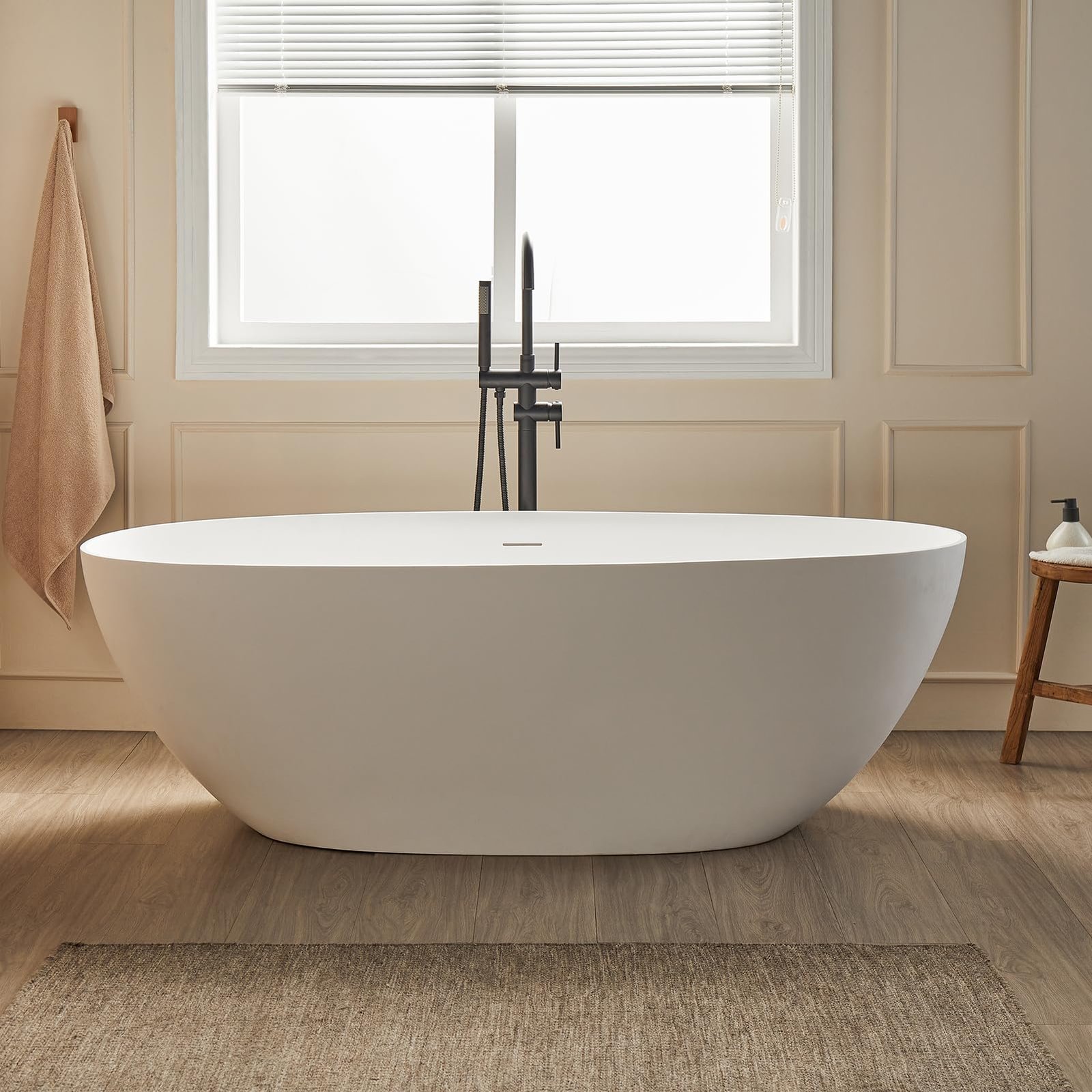 Oval freestanding bathtub with black faucet in a modern bathroom