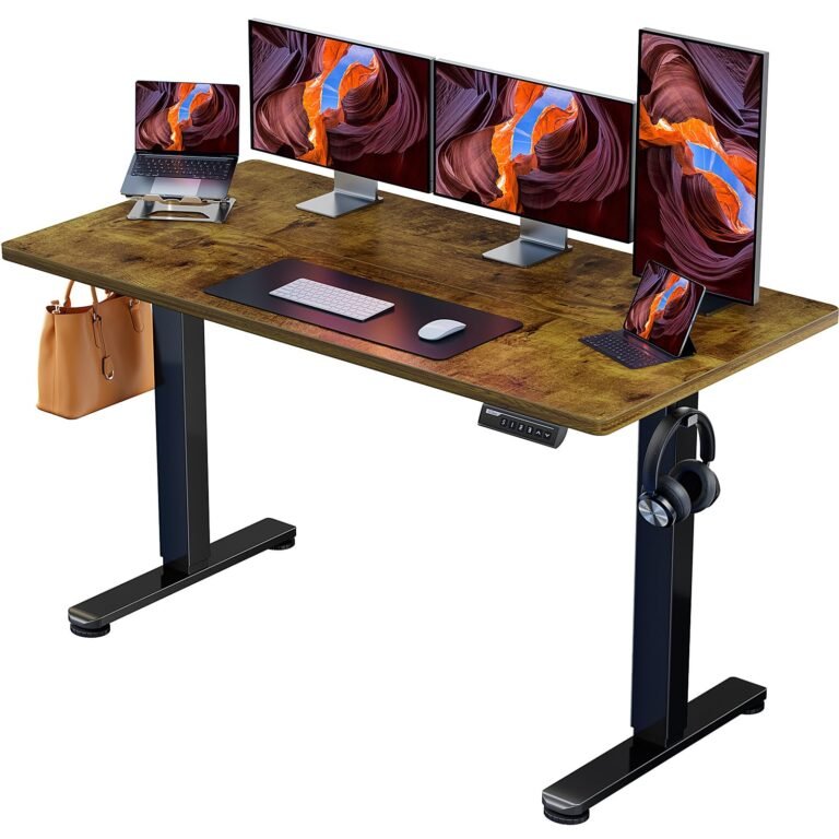 Adjustable standing desk with multiple monitors, laptop, and accessories