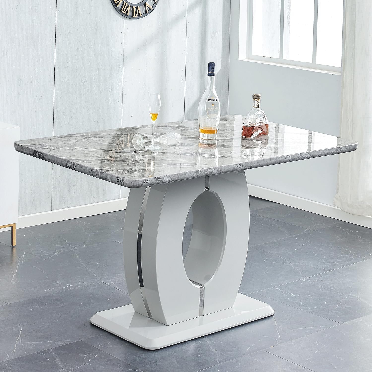 Modern dining table with marble top, white base, and liquor bottles