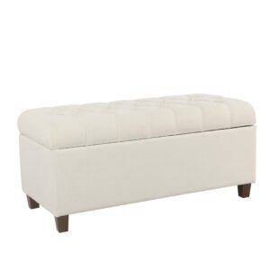 Cream-colored tufted storage bench with dark wooden legs, isolated on white background