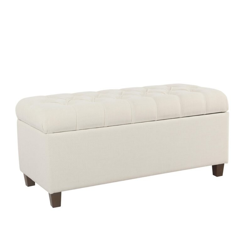 Cream-colored tufted storage bench with dark wooden legs, isolated on white background