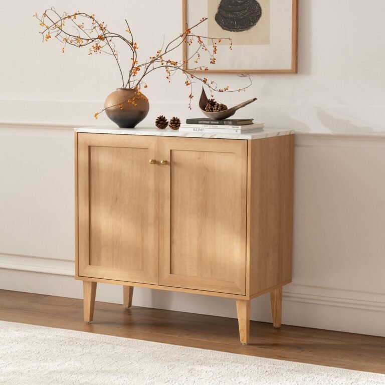 Wooden cabinet with marble top, vase with branches, and decorative items