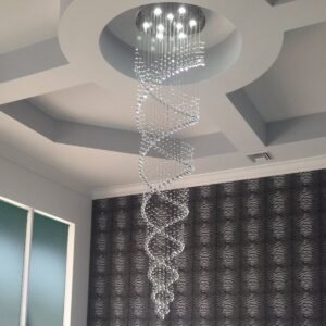 Spiral crystal chandelier hanging from a recessed ceiling, patterned wallpaper