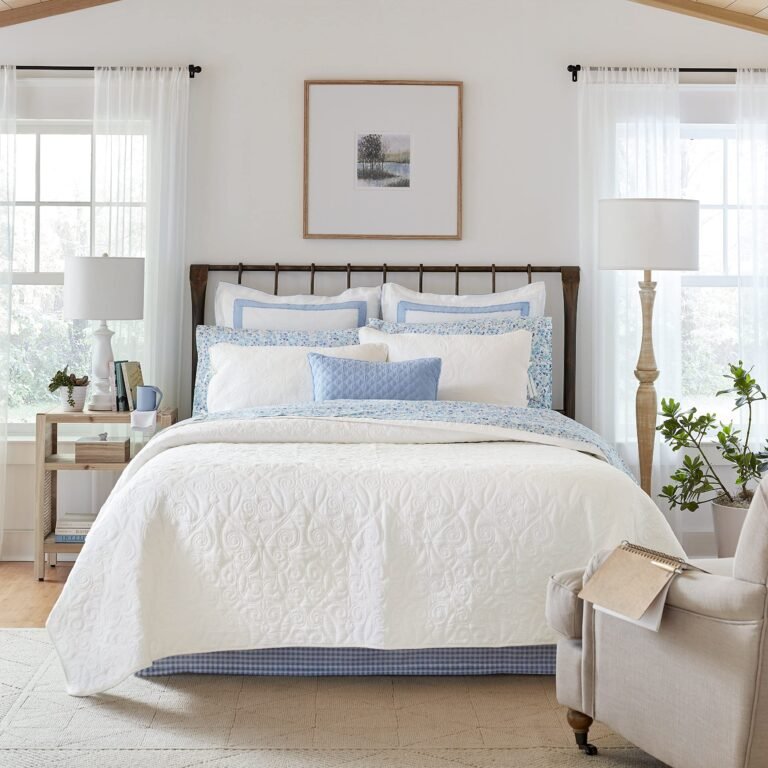 Cozy bedroom with a bed, white quilt, blue accents, and a chair
