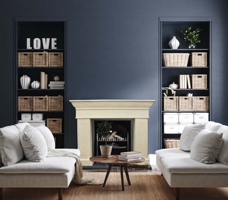 Living room with fireplace, bookshelves, white sofas, and a coffee table