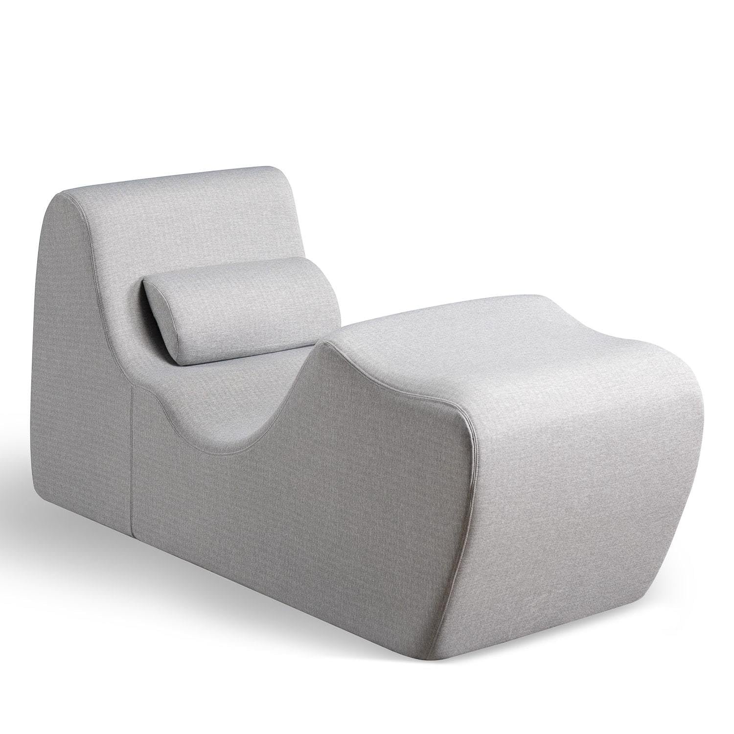 Gray chaise lounge with a curved design and headrest pillow