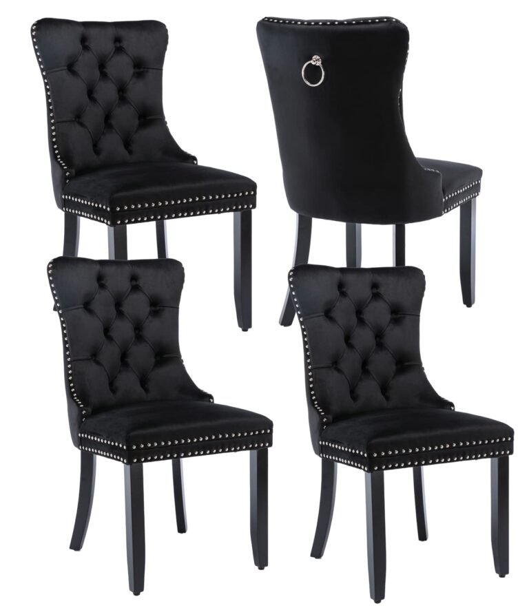Four black velvet chairs with button tufting and silver nailhead trim