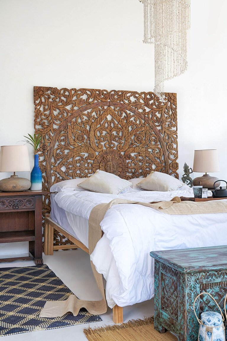 Bedroom with carved wooden headboard, bed, and decorative chandelier